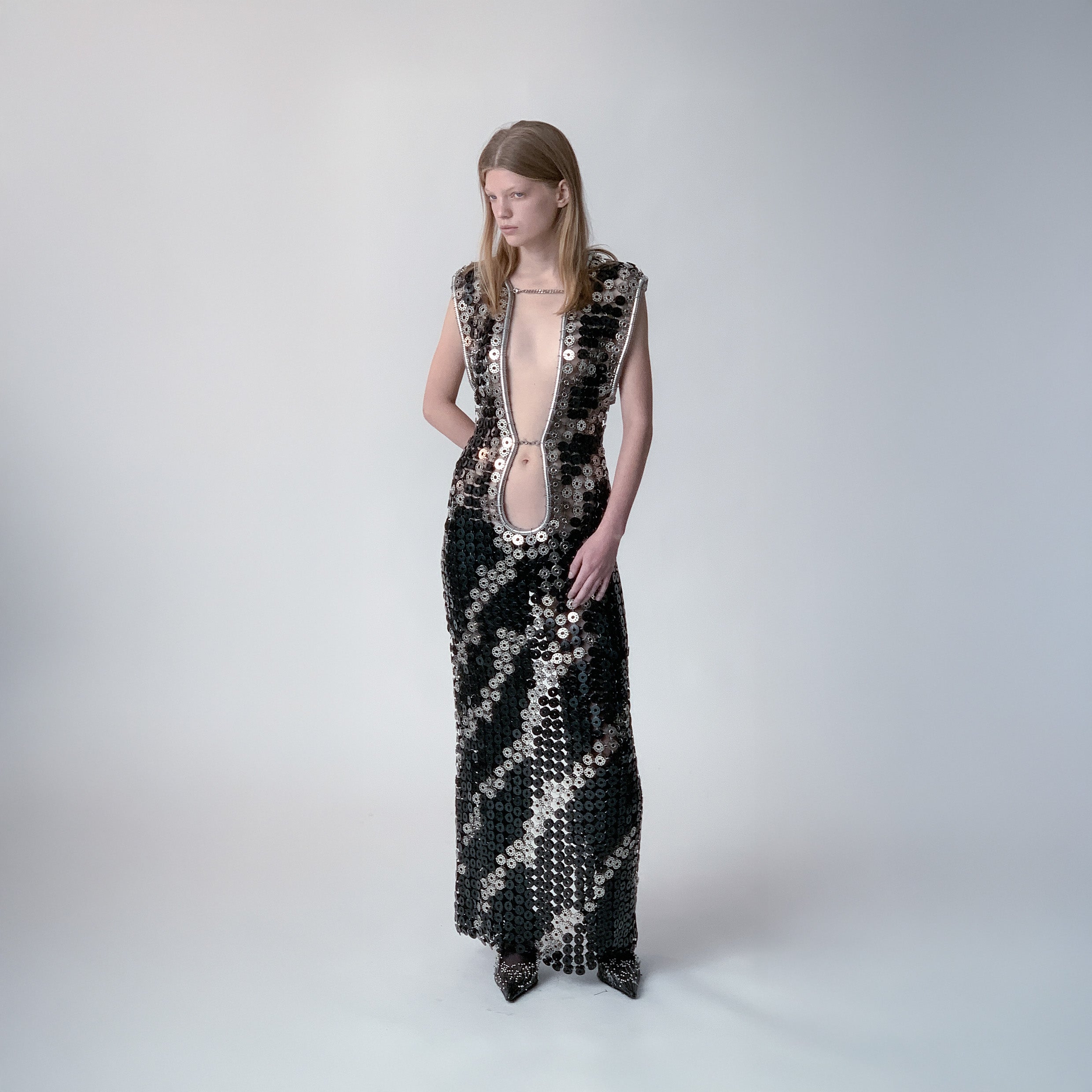 person wearing a long dress out of black and metallic  bobbins in a zebra pattern on a light gray background 