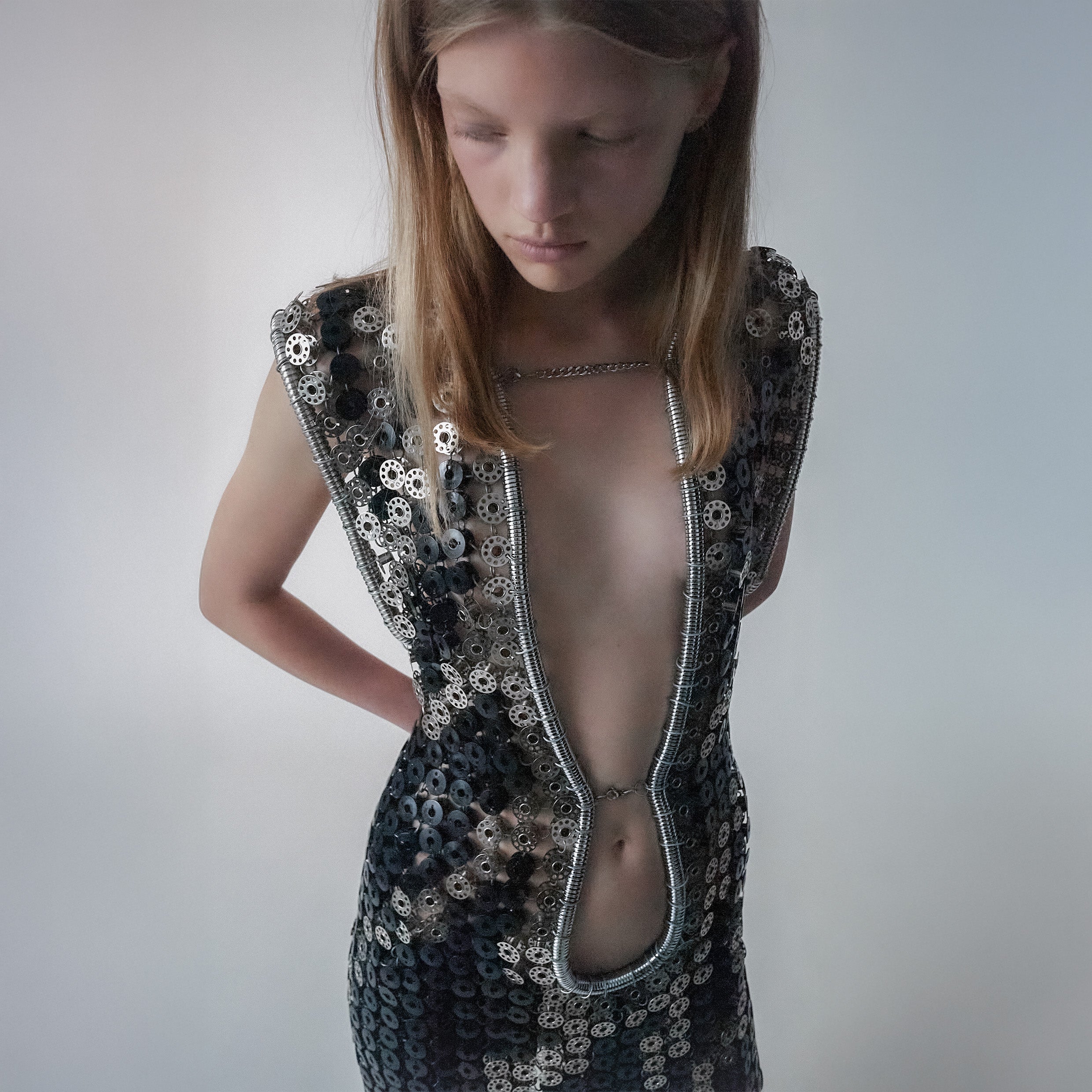 person wearing a long dress out of black and metallic  bobbins in a zebra pattern on a light gray background 