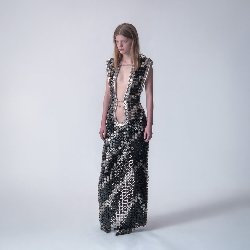 person wearing a long dress out of black and metallic  bobbins in a zebra pattern on a light gray background 